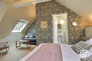 a bedroom with a bed and a couch in a room at Fontaine aman in La Roche-Derrien