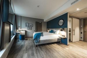 Un dormitorio con una cama grande y una pared azul. en HARBR Hotel Konstanz, a member of Radisson Individuals, en Constanza 122 fotos más
