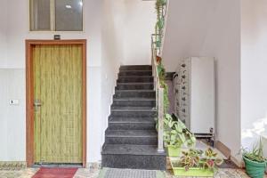 a stairway with a wooden door and some plants at HOTEL O LAXMAN GRAND in Tapovan