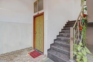 a staircase leading to a door with a red mat at HOTEL O LAXMAN GRAND in Tapovan
