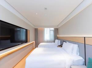 Ένα ή περισσότερα κρεβάτια σε δωμάτιο στο JI Hotel Shanghai Hailun Road Subway Station