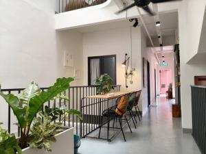 a hallway with a table and chairs and plants at The Brownstone Hostel & Space in Ipoh