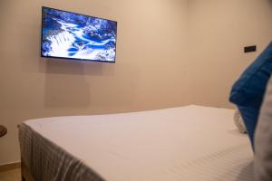 a bedroom with a bed and a tv on the wall at Sea Bloom Villa in Kamburugamuwa