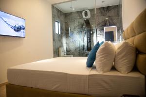 a bed with two pillows and a television on a wall at Sea Bloom Villa in Kamburugamuwa