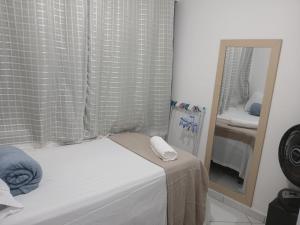 a small bedroom with a mirror and a bed at At Suites in Maragogi +6 photos