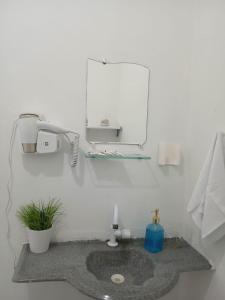a bathroom with a sink and a mirror at At Suites in Maragogi