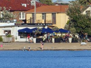 two children playing on the beach next to the water at Modern room in Williamstown in Williamstown