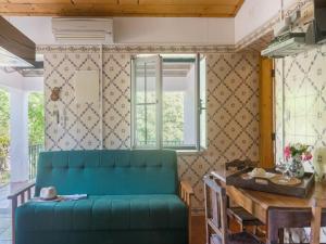 a living room with a green couch and a table at Wine Country Home in Alentejo in Montemor-o-Novo