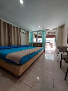 a bedroom with a large bed with blue pillows at TaKaYai GuestHouse in Cha Am