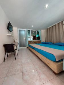 a bedroom with a large bed and a desk at TaKaYai GuestHouse in Cha Am