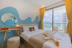 a bedroom with a bed with a stuffed animal on it at THE SONG CĂN HỘ GẦN BÃI SAU THÁP TAM THẮNG - Po'sHomestay Luxury Bãi Sau in Vung Tau +105 photos