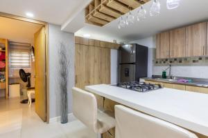 a kitchen with a white counter top and wooden cabinets at Apartamento con Jacuzzi privado Cerca al Metro y al Mayorca in Envigado
