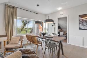 a dining room and living room with a table and chairs at Alte Schule Westerhever Vollerwiek in Westerhever
