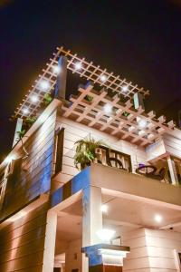 a building with lights on it at night at Saya's Abode - Railview Suites in Tezpur