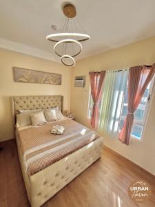 een slaapkamer met een groot bed en een kroonluchter bij Urban Haven Davao in Davao City