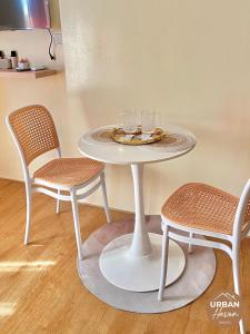 een tafel met twee stoelen en een tafel met glazen erop bij Urban Haven Davao in Davao City