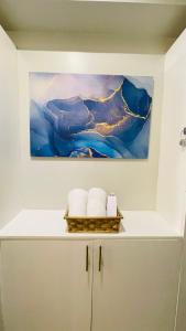 un dipinto su una parete sopra uno scaffale con asciugamani di Casa Azul Serin East Tagaytay a Tagaytay