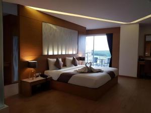 a bedroom with a large bed with a large window at The Vista Hotel By Satit Group in Sadao +187 photos