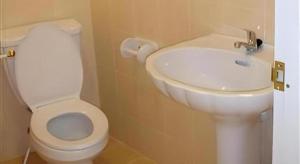 Un baño con un inodoro blanco y un lavabo. en Baan Rim Khong Hotel, en Ban Tha Khwai