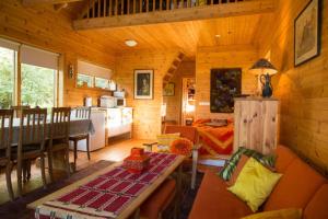 ein Wohnzimmer und eine Küche eines Blockhauses in der Unterkunft Beautiful Cottage in Hveragerdi in Hveragerði