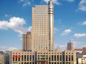 KenliにあるDongying Dongsheng Hotelの上に塔がある高い建物