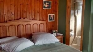 a bedroom with a bed with a wooden head board at Chalés Rincão Comprido in Canela +79 photos