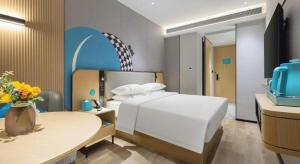 a bedroom with a bed and a table with a vase of flowers at City Comfort Inn Zhongshan Lihe Square Walmart Branch in Zhongshan +215 photos