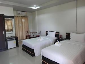 a hotel room with two beds and a table at Baan Ing Daan in Ban Non Nam Thaeng
