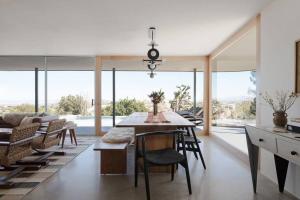 une salle à manger avec une table, des chaises et des fenêtres dans l'établissement Luxury Villa Pool & Spa Looking Glass, à Yucca Valley