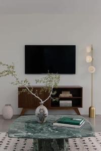 un salon avec une table et un vase avec une plante dans l'établissement Luxury Villa Pool & Spa Looking Glass, à Yucca Valley