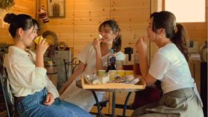 Eine Gruppe von drei Frauen, die an einem Tisch sitzen und Essen essen. in der Unterkunft seisen-ryo - Vacation STAY 95870 in Gujō