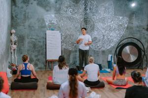 a man giving a presentation to a group of people at Dedeane Hotel & Yoga Retreat in Ubud