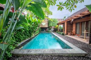 an image of a swimming pool in front of a house at Dedeane Hotel & Yoga Retreat in Ubud