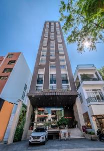 une voiture garée devant un grand immeuble dans l'établissement Astica Hotel Nha trang, à Nha Trang