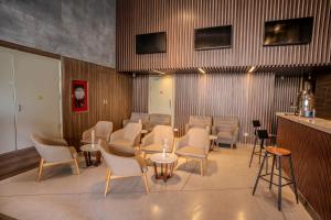 une salle avec des chaises, des tables et un bar dans l'établissement Astica Hotel Nha trang, à Nha Trang