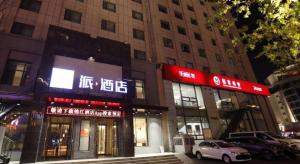 Un par de edificios en una calle de la ciudad por la noche. en PAI Hotel·Changchun Jilin DaLu, en Changchún