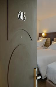 Postel nebo postele na pokoji v ubytování Hôtel & Appartements Monsigny