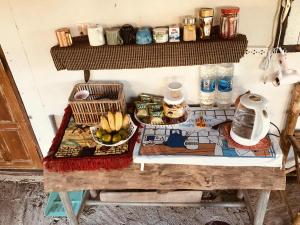 a table with a bowl of fruit and a plate of food at Sparrow Hut in Pai