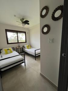 une chambre avec deux lits et deux miroirs au mur dans l'établissement CoronadoWind, à Las Lajas 11 autres photos