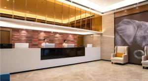 eine Lobby mit zwei Personen am Tresen in der Unterkunft JTOUR Inn Yulin Railway Station Industrial Products Market in Yulin