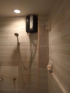 baño con ducha y teléfono en la pared en บ้านเพื่อนโฮมสเตย์, en Ban Muang (1)