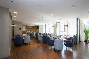 een restaurant met blauwe stoelen en tafels in een kamer bij Echarm Hotel An'xi Hengxing Coach Station in Anxi