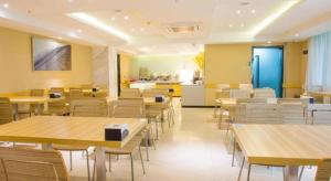 ein Esszimmer mit Tischen und Stühlen und eine Küche in der Unterkunft City Comfort Inn Fangcheng Qunxing Avenue in Fangchenggang