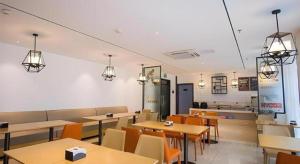 a dining room with tables and chairs and lights at City Comfort Inn Suzhou Zhangjiagang Jingang Changjiang Xi Road in Xiwujieqiao