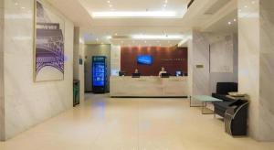 eine Lobby eines Hotels mit zwei Personen an der Theke in der Unterkunft City Comfort Inn Liuzhou High-speed Railway Station in Liuzhou