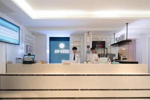 dos hombres parados detrás de un mostrador en una cocina en Xana Lite· Xi'an South Gate Yongningmen Subway Station, en Xi'an