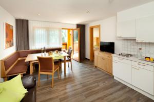a kitchen and dining room with a table and chairs at Aparthotel Brunnenhof in Damuls