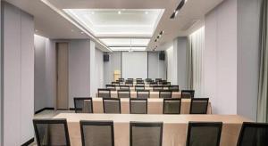 武漢市にあるEcharm Hotel Wuhan Huangpi Xiangyang Avenueの長いテーブルと椅子のある会議室