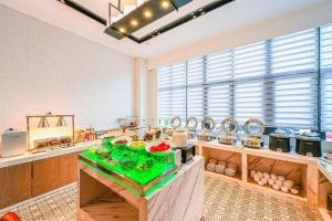 a large kitchen with a green counter in a room at Echarm Hotel Wuhan High-speed Rail Peace Park Metro Station in Wuhan