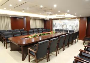 Una gran sala de conferencias con una mesa larga y sillas. en City Comfort Inn Shaoyang Xinning, en Xinning